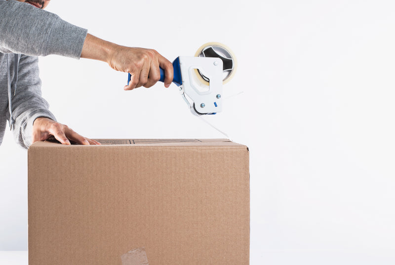 Free shipping on orders over $5 box with someone adding tape to it