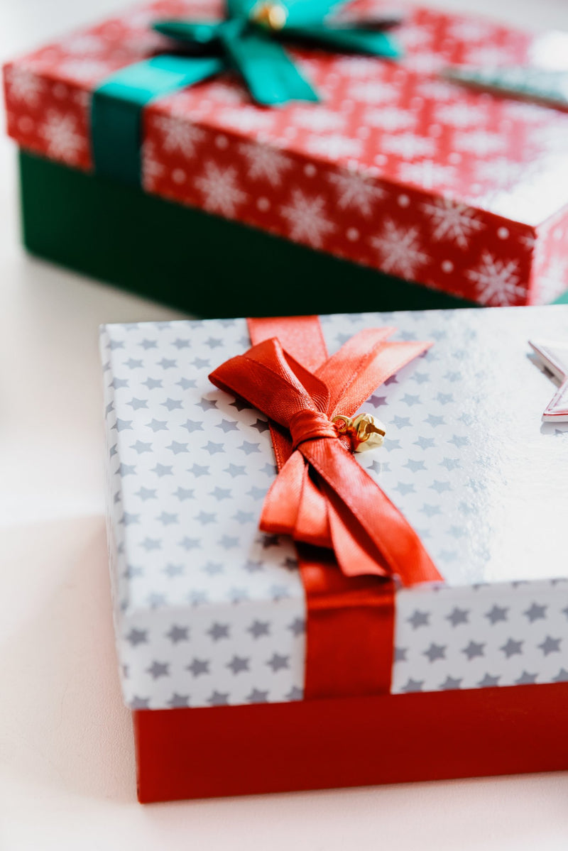 Two gift boxes with ribbons on a light background
